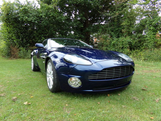 Angled front view of finished body repair work by Precision Paint on a blue Aston Martin Vanquish S