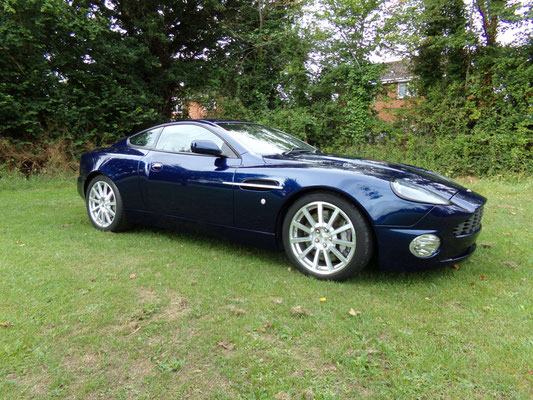 Angled view of finished body repair work by Precision Paint on a blue Aston Martin Vanquish S