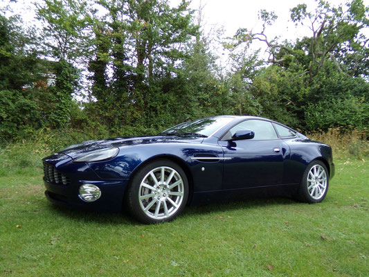 Angled side view of finished body repair work by Precision Paint on a blue Aston Martin Vanquish S