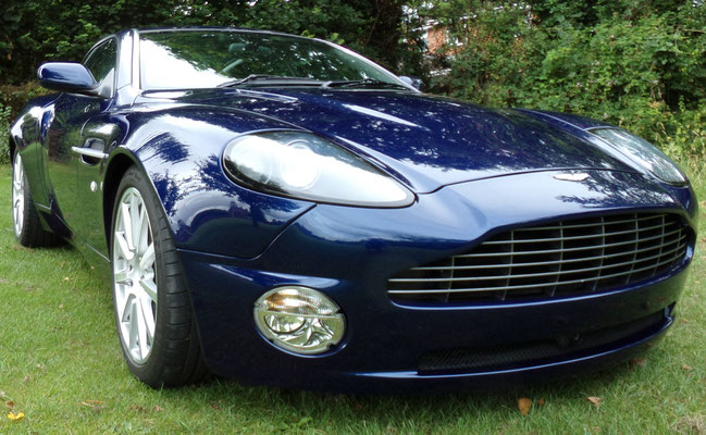 Close-up of finished body repair work by Precision Paint on a blue Aston Martin Vanquish S