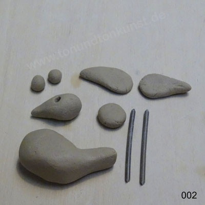 Aus der grossen Kugel Körper und Schwanz in einem Stück herausformen. Aus der nächsten Kugel Kopf mit Schnabel in einem Stück formen, Augenlöcher stechen.