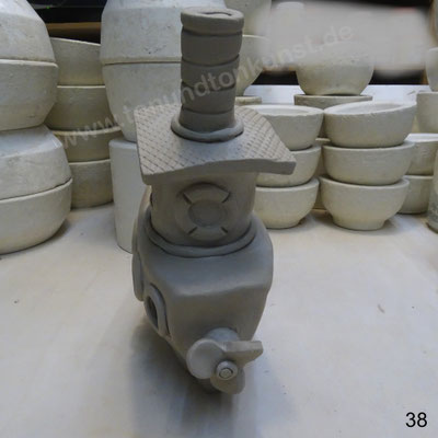 Die Schiffschraube auf einen dickeren Kanthaldrahtstift aufspiessen und durch den angeschlickerten Tonzylinder und das Heck stecken (für die Stabilität) . Ein Tonkügelchen auf das Drahtende auf der Schiffschraube verstreichen.