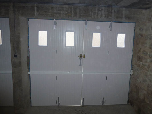 Porte de garage PVC avec hublot et barre de renfort vue de l'intérieur droite.