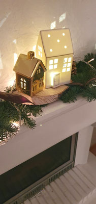 Goldenes und weiß-goldenes LED-Haus auf einer Birkenscheibe mit Tanne dekoriert.