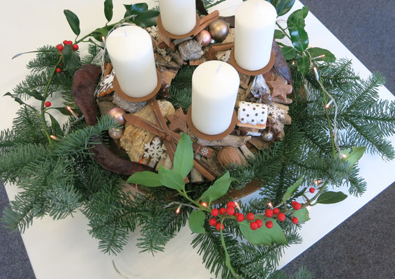 Variante 2: Brauner Deko Adventskranz mit cremefarbenen Kerzen, Ilexzeigen, Nobilistanne und braunen Glaskugeln dekoriert.