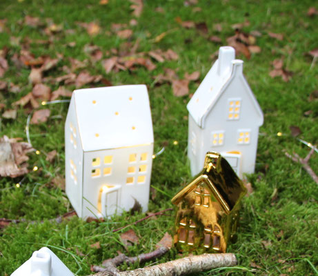 LED Lichthäuser in glänzendem weiß und gold sehen super auf grünem Moos aus