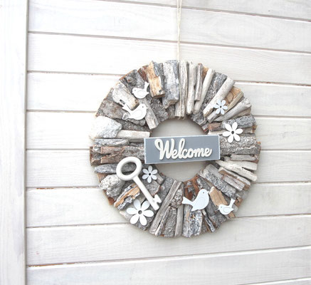 Variante 2: Weiß-grauer Holzkranz mit "Welcome" Schild und Porzellanschlüssel.
