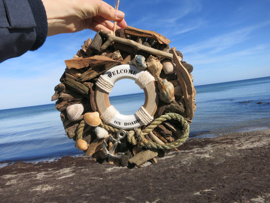 Türkranz mit Rettungsring mit "Welcome on Board" - gefundenem Fischerseil und Anker am Ostseestrand.