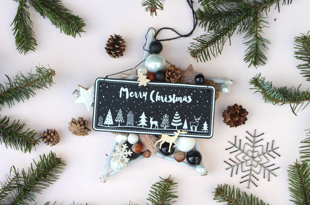 Weihnachtlicher Stern mit schwarzem "Merry Christmas" Schild und modernen Dekorationsaccessoires in schwarz - weiß.