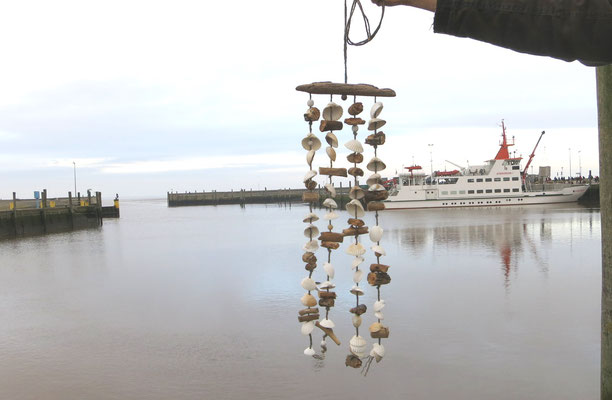 Nordische Hänge-Deko mit weißen Muscheln und Treibhölzern am winterlichem Hafenbecken fotografiert.