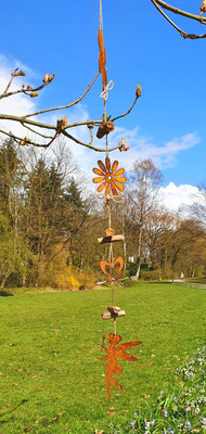 Edelrost Girlande mit Gartenelfe und Blüten für deine Gartendeko an einer Kastanie schwingend.