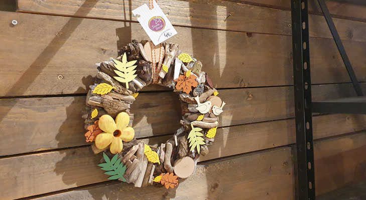 Holzkranz mit sommerlichen, farbenfrohen Blüten und Blättern.