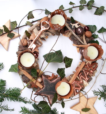Adventskranz aus braunem Treibholz mit vier braunen Maxiteelichtern aus Metall und XMAS Schild in der Farbe Kupfer..