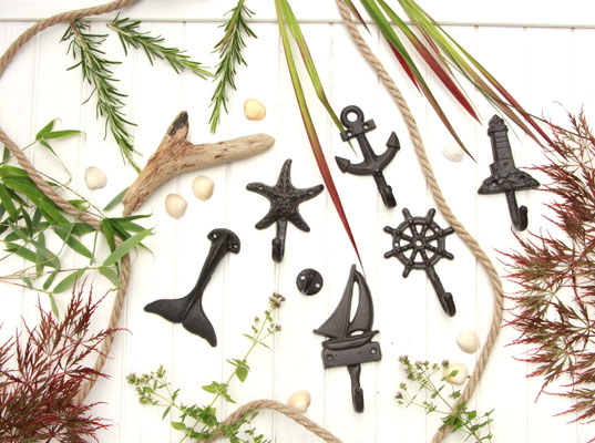 Wandhaken aus dunkelbraunem Gusseisen. Maritime Kleiderhaken Kollektion von - Sterne überall -: Walflosse, Segelboot, Steuerrad, Seestern, Leuchtturm, Anker und einfacher, runder Wandhaken.