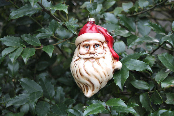 Weihnachtsmanngesicht aus Glas mit weißem Rauschebart und roter Mütze.