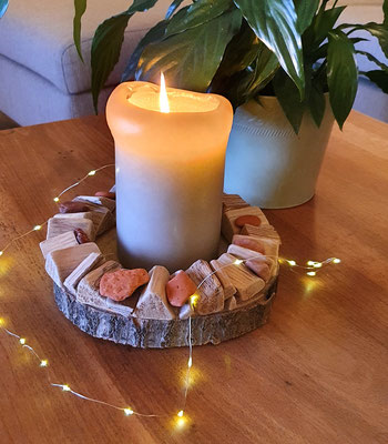 Dekoidee: Holzkranz mit Kerze und Lichterkette dekoriert.