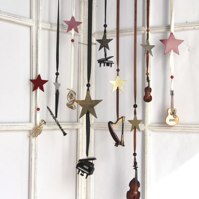 Viele Minimusikinstrumente am Seidenband als Fensterdekoration arrangiert.