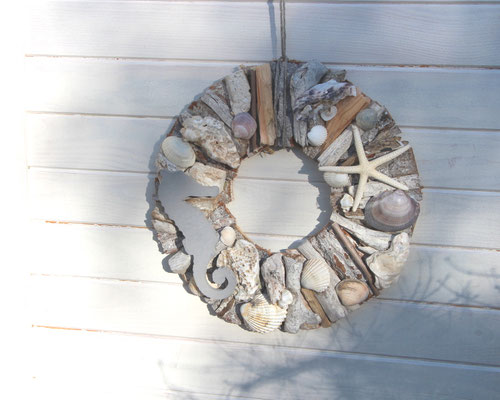 Weiß-brauner Treibholzkranz mit Muscheln, grauem Seepferdchen und einem Seestern.