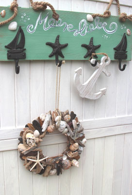 Passt perfekt zusammen: Maritime Wandgarderobe mit farblich passendem handgefertigtem Kranz mit Muscheln und Schwemmholz.