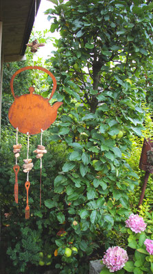Edelrost Teekessel am Gartenhäuschen mit Messer, Gabel und Löffel als Abschluss.