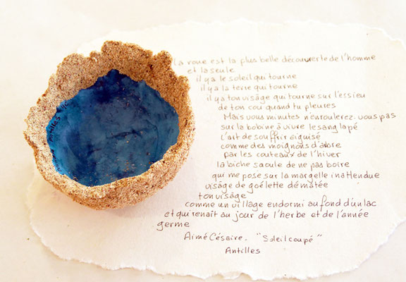 Coupe des Antilles constituée de sable et de papier avec un extrait de poème d'Aimé Césaire