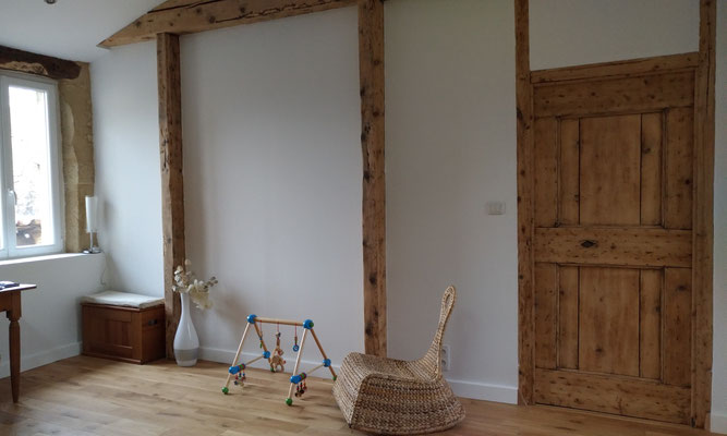 Rénovation d'une maison en pierre. Bureau avec poutres et menuiseries poncées pour valoriser le bois ancien. Parquet en chêne naturel.