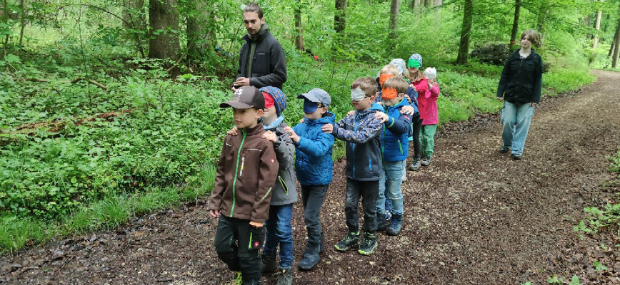 Die Schüler laufen mit verbundenen Augen in einer Schlange