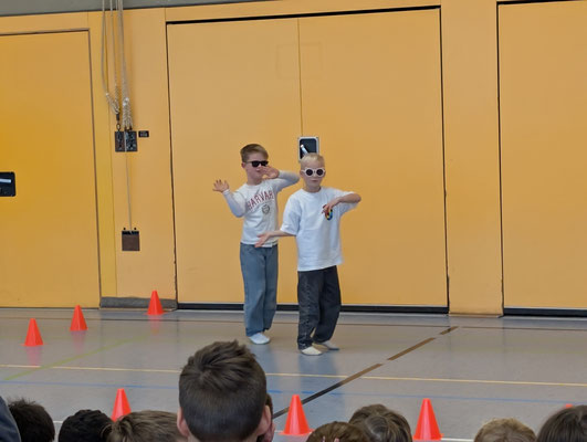 Zwei Jungen der Fledermausklasse tanzen. Beide tragen eine Sonnenbrille.