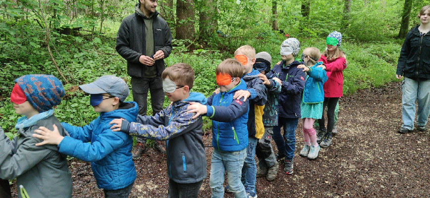 Die Schüler haben die Augen verbunden und laufen in einer Schlange