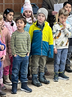 Einige Erstklässler stehen mit ernstem Gesicht vor dem Nikolaus