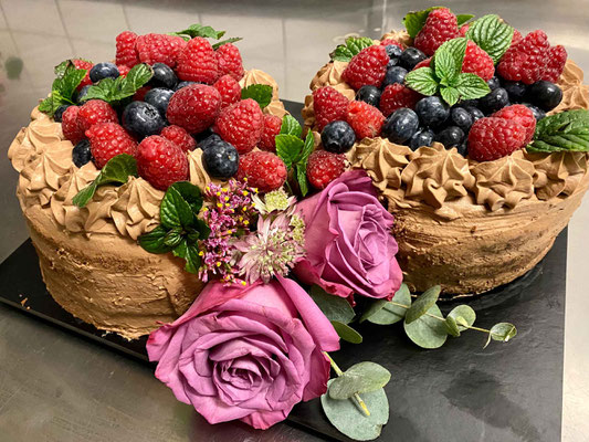 verzierte Torten mit Früchten und Blumendeko