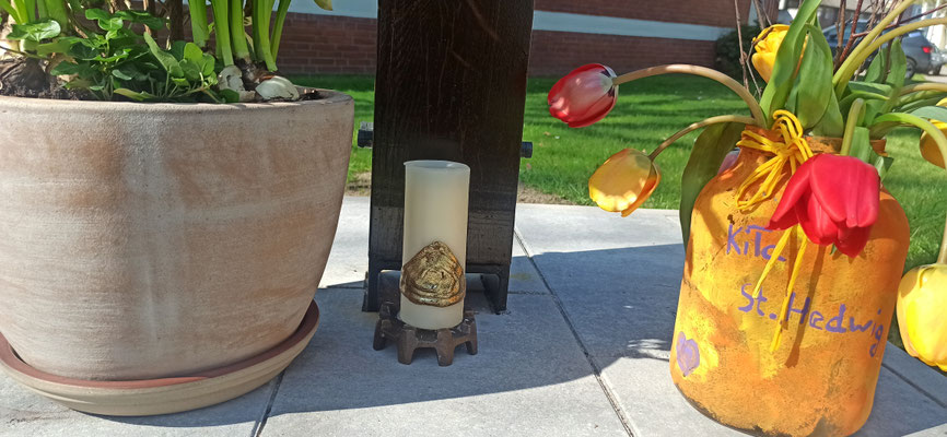 Die von Wilhelm van Gessel gestaltete Kerze zwischen Blumen seiner Töchter und der Vase der KiTa-Kinder.