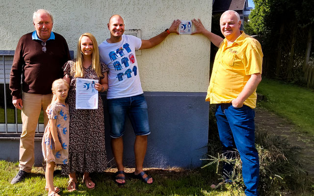 Kay Thörmer, 1. Vorsitzender des NABU Herne, überreicht der Familie Wiesche die Urkunde und die Plakette zum "Schwalbenfreundlichen Haus".