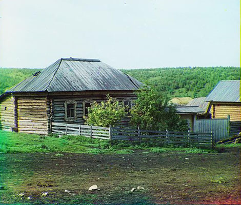 Photo recolorisée du début du 20e siècle montrant les maisons et un jardin de cuisine. 