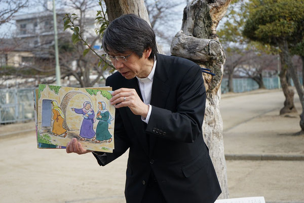 森牧師は紙芝居をはじめてメッセージ。　空っぽの墓の前に立つ婦人達の姿が見えます。