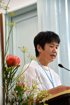 2022年7月17日（日）紀子さんと献花が見事にマッチしてます。紀子さんがペンだこをつくりなが、座卓に一日座って書き上げられた証しを語っておられます。