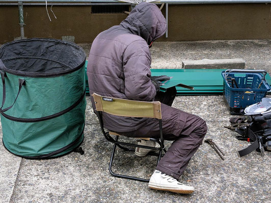 2025年1月10日（金）午後3時45分　牧師撮影　寒風のためこのような格好でお仕事される職人さんです。裏手の隣家側に、見えない所に実は屋根があります。礼拝前にお祈りを会わせるお部屋の奥側の窓辺りの上に屋根があるのです。そこのガルバリウム鋼板の鈑金作業をしておられました。