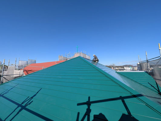 2025年1月11日（土）11時過ぎ　附属館の屋根工事の仕上げに入っていてよいタイミングでした。お一人で黙々と職人さんが、相当に集中して作業中でした。大空の元、緑色の屋根が映えます。