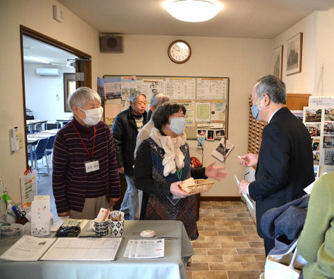 2025年1月26日（日）午前10時少し前。この日講師としてお迎えした橫野朝彦先生が到着。旭東教会名物・福音くじを引いて頂く場面です。説明する光代さんときよみさん。そして、後には十文字平和教会のはるおさんのお姿も。