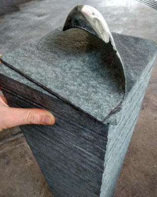 Grabstein aus Diabas mit sich ablösendem Blatt.
