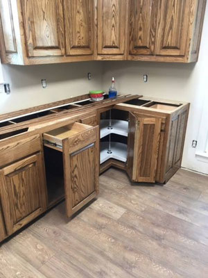 Cabinets done in Ash with "Chocolate" stain & lacquer finish. Lazy Susan and built in Trash bin drawer