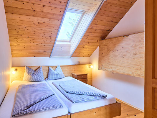 Doppelbett im Kinderzimmer mit Dachflächenfenster
