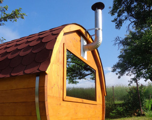 Rückseite der Fasssauna mit verspiegeltem Fenster am Biobauernhof Stadler