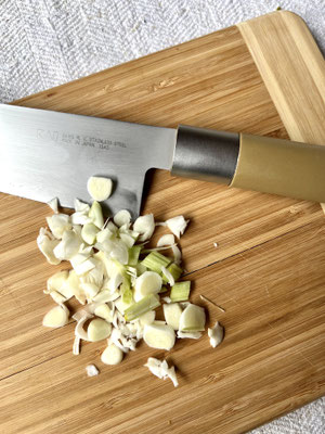 Geschnittener Knoblauch, zerstoßener Pfeffer & gehackte Kräuter – vorbereitete Würzzutaten