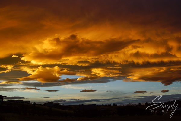 Tekapo, rot-goldiger Sonnenuntergang mit blauem Strich am Horizont