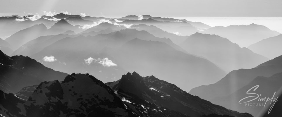 Flug über die südlichen Alpen,schwarzweiss Bild mit Bergen und Wolken, aus dem Flugzeug