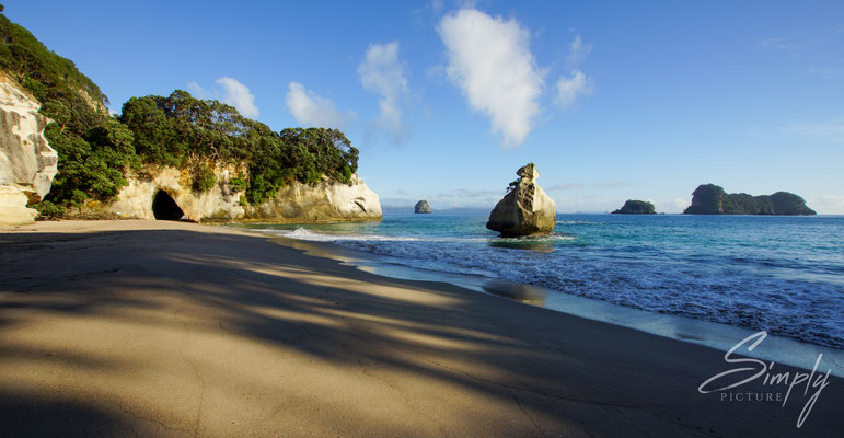 Hahei, Cathedral Cove, Menschenverlassener Strand kurz nach Sonnenaufgang-blauer Himmel mit einzelner Wolke