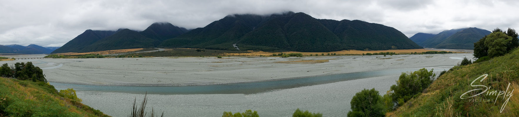 Canterbury, Flussbett mit viel Kies und intensiv, blauem Fluss in mitten der Berge und Wälder in den neuseeländischen Alpen