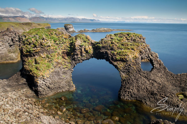 Gesteinsformation mit Bogen im Meer bei Gatklettur.