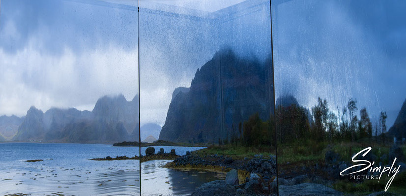 Spiegelung in einem Kunstwerk. Einsamer Fiord auf den Lofoten bei Regenwetter.
